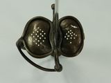 a small metal object with holes in the middle of it
