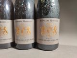 three bottles of wine are lined up on a table