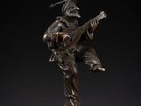 a bronze figurine of a man playing a guitar
