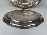 pair of silverplated serving dishes on stands on a table