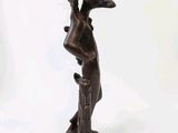 a bronze statue of a woman holding a bird on her arm