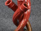un vase rouge orné de deux tuyaux rouges