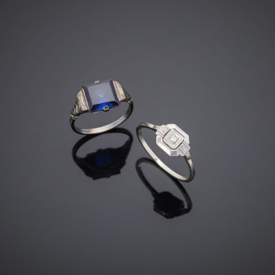 two rings and a ring with a blue stone on a black surface