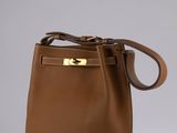 a brown leather handbag with gold hardware on the handle