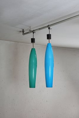 two blue and green lights hanging from the ceiling