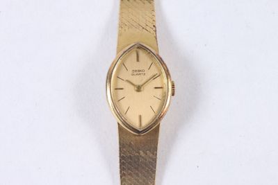 une montre-bracelet en or avec un bracelet en or sur un fond blanc
