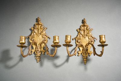 une paire d'appliques murales dorées, ornées chacune d'un cherensil