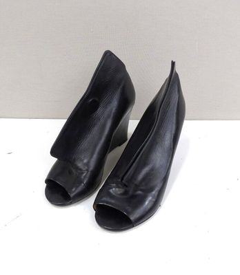 pair of black leather high heeled shoes on a white surface