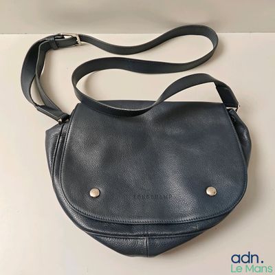 the small black purse is sitting on a white table