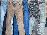 plusieurs paires de jeans suspendues à une corde à linge dans un entrepôt