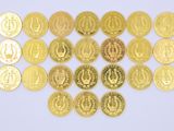 several different types of gold coins are arranged on a white surface