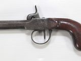 a close up of a gun with a wooden handle on a white surface