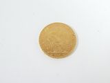 a close up of a gold coin on a white surface