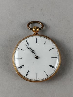 a gold pocket watch with roman numerals on the face