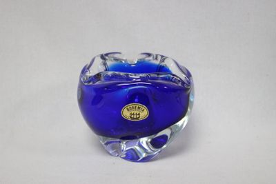 un vase en verre bleu orné d'une étiquette dorée