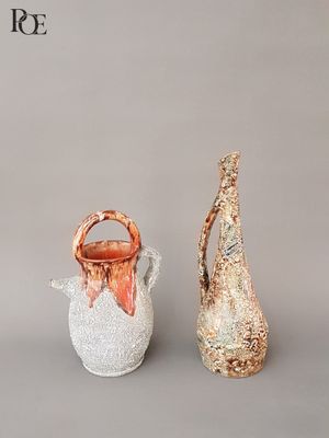 three vases sitting next to each other on a gray surface