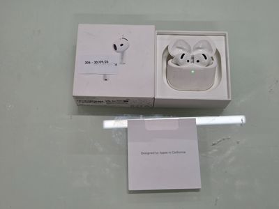 des AirPods d'Apple dans une boîte, avec un stylo à côté