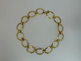 a close up of a gold chain bracelet on a white surface