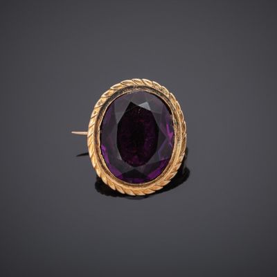a close up of a purple stone in a gold ring