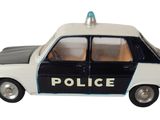 une petite voiture de police posée sur une surface blanche
