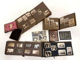 Plusieurs vieilles photos de personnes sont exposées dans une boîte posée sur une surface blanche