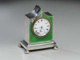 une petite horloge verte surmontée d'un oiseau