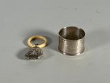 une coupe en argent et une bague en or posées sur une table