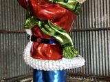 une décoration de Noël représentant le Père Noël tenant un cadeau