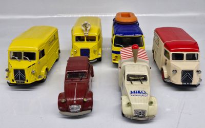 five toy cars that are lined up on a white surface