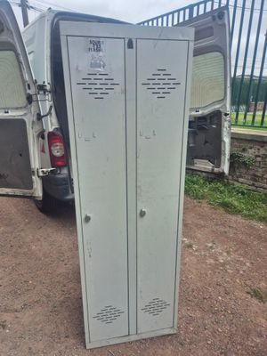 une camionnette blanche garée à côté d'un casier métallique