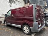 a red van parked in a parking lot next to a building