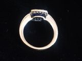 Gros plan sur une bague en or ornée d'une pierre bleue