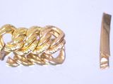 une bague en or et un couteau posés sur une surface blanche