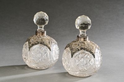une paire de flacons de parfum anciens en cristal taillé posés sur une table