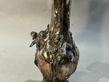 un vase en argent posé sur une table