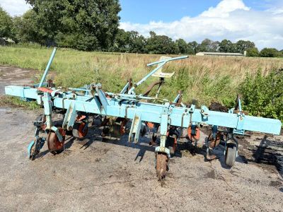 a blue plow that is sitting in the dirt