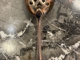 a spoon with a handle on a marble surface