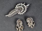 three pieces of silver jewelry on a black surface