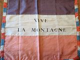 un gros plan sur un drapeau posé sur un parquet, sur lequel sont inscrits des mots