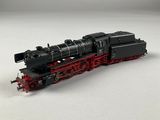 une image représentant une locomotive noire et rouge sur un fond blanc