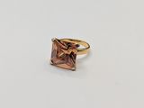 a close up of a ring with a pink stone in it