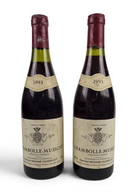 deux bouteilles de vin posées l'une à côté de l'autre sur une surface blanche
