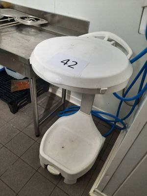 une petite table sur laquelle se trouve un seau, dans la cuisine