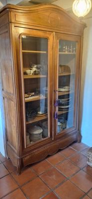 a wooden cabinet with glass doors in a room