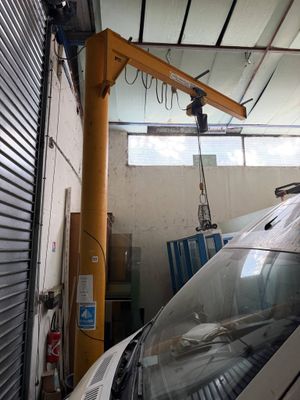 a car that is parked in a garage with a crane on top of it
