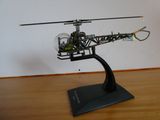 une maquette d'hélicoptère posée sur un socle, sur un plancher en bois