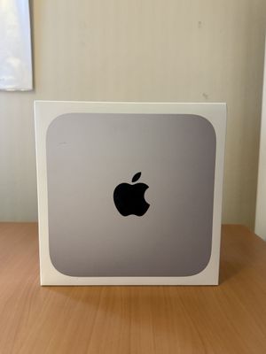 un ordinateur Apple posé sur une table en bois près d'une fenêtre