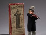 a small figurine of a man with a violin in front of a box