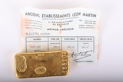 un lingot d'or posé à côté d'un ticket de caisse sur une table
