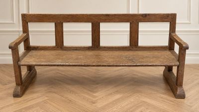 un vieux banc en bois posé sur un parquet en bois dur